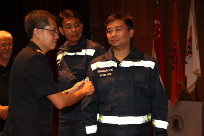<p>COMR Eric Yap placing the Heavy USAR Team Badge on LTC Alvin Low, ORNSmen</p>