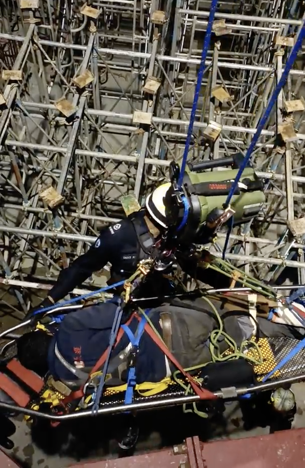 WO1 Muhammad Umar descended the tower crane with the casualty secured to the stretcher. The power ascender (in green) is rigged above the rescuer and casualty.     
